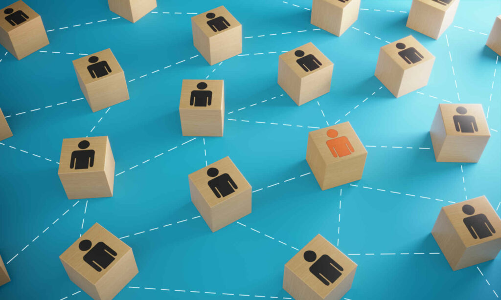 Orange colored business man icon on wooden block between the black ones, symbolizing leadership and social network connections. ( 3d render )