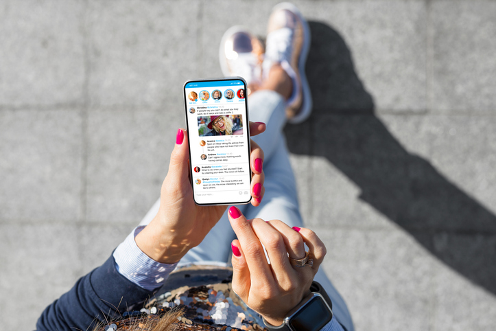 Realtor using social media microblogging app on her smart phone.